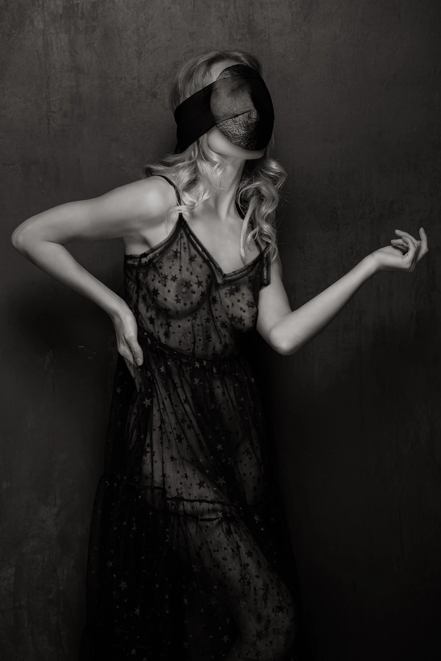 Gallery fashion photo of a womand wearing a wooden mask and a see-through dress in black & white